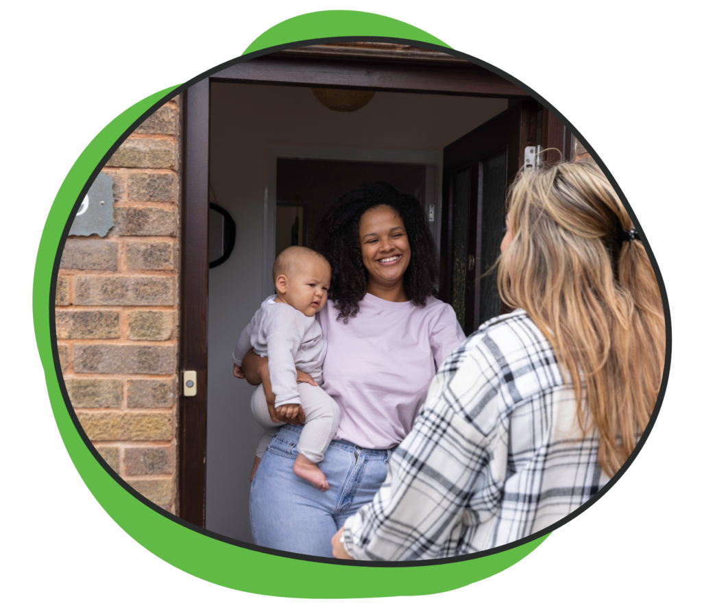 mom with baby greeting home visitor at door